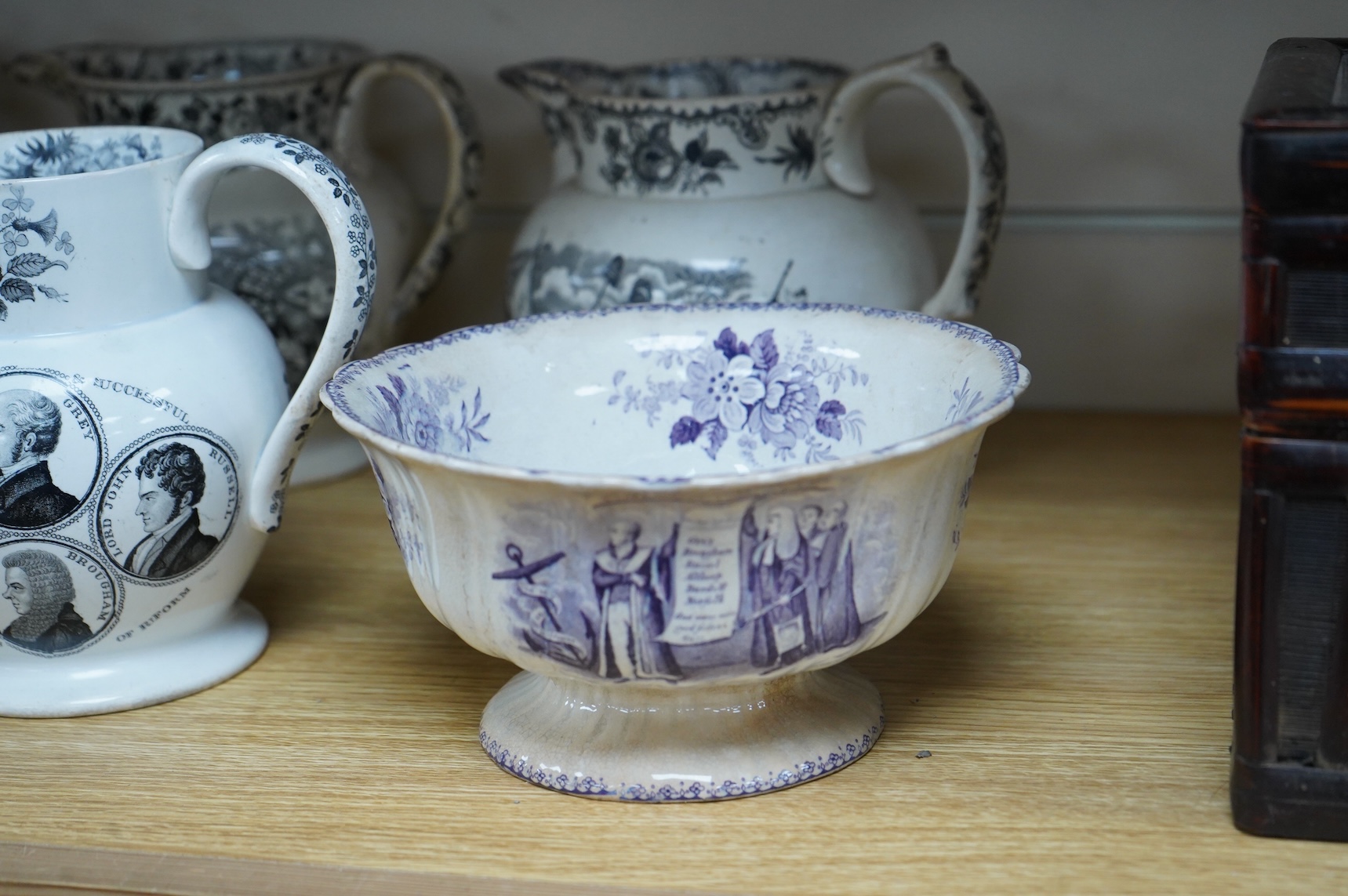 Six contemporary political themed earthenware pottery jugs and a pedestal bowl commemorating the 1832 Reform Bill, with transfer printed symbolic scenes of the Houses of Parliament, details regarding the voting, portrait
